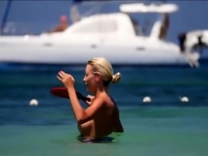 Beach voyeur finds a busty blonde babe enjoying the hot sun