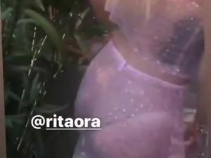 Rita Ora dancing outside in a pink dress